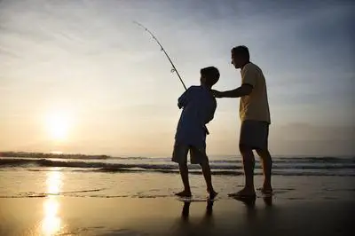 Boy and father fishing
