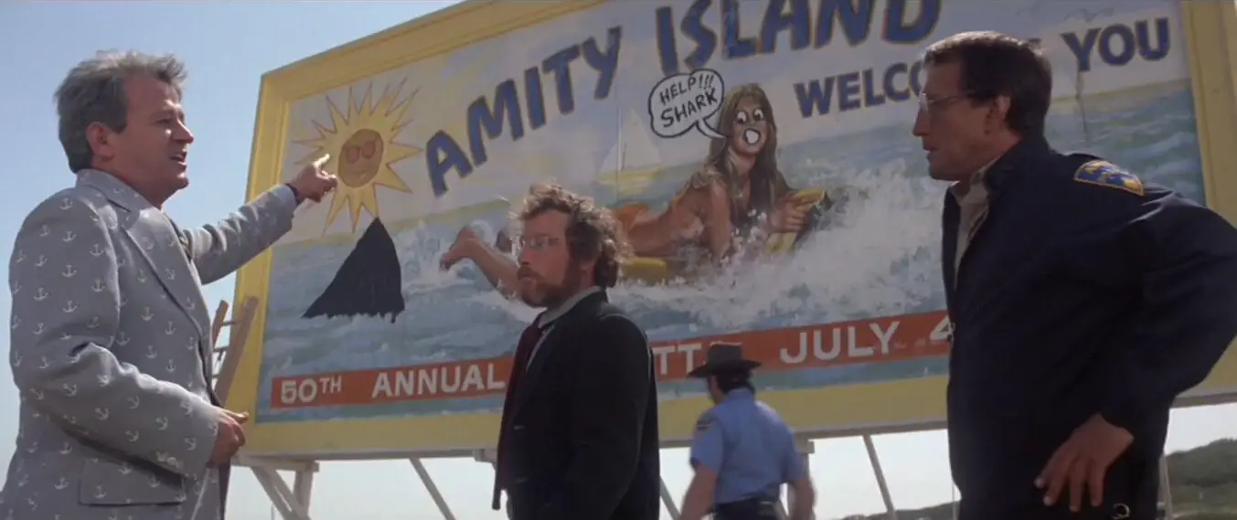 A graffitied billboard foretells the danger of a massive great white shark in the 1975 film JAWS.